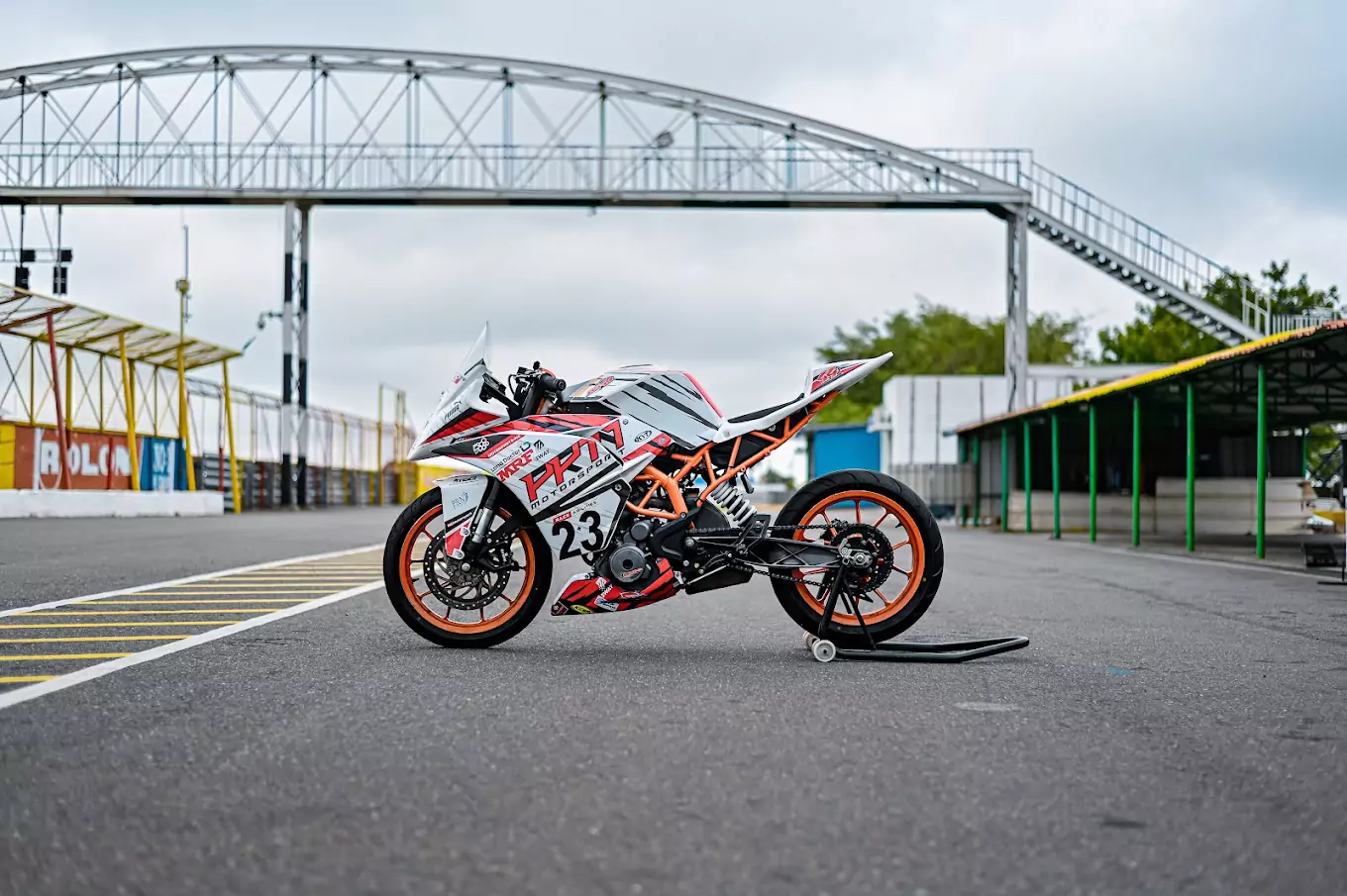 Custom KTM racing bike in orange and white with MRF sponsorship, ideal for advanced motorcycle riding courses on professional race tracks.