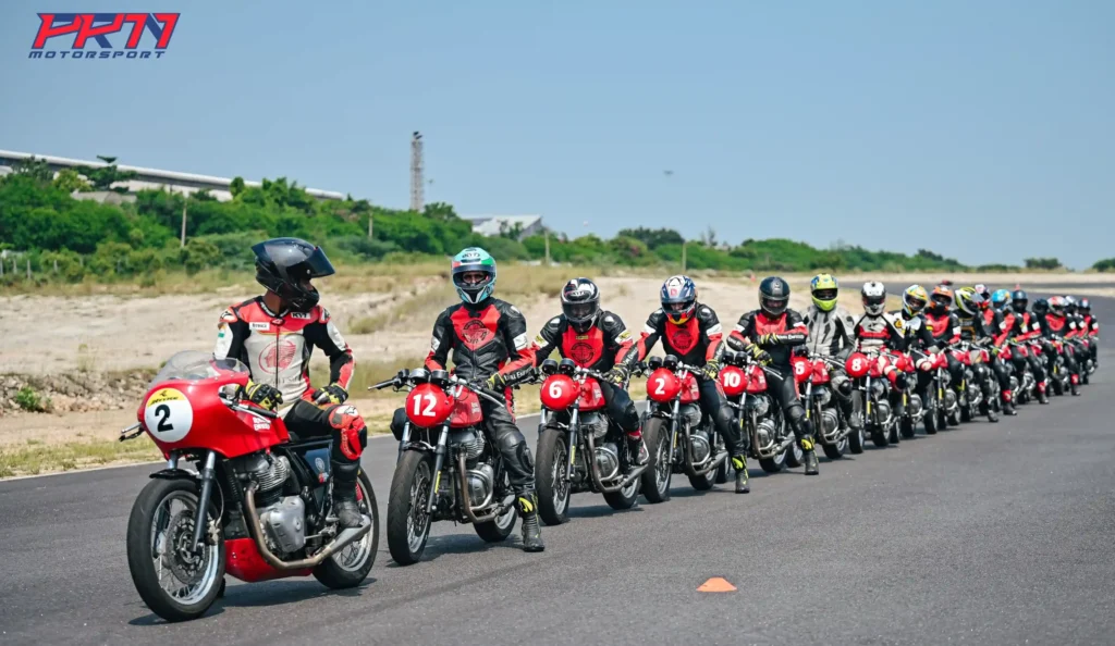 A lineup of motorcycle racers in PRN Motorsport red and black gear, ready for an exhilarating track race at bike racing sport events.