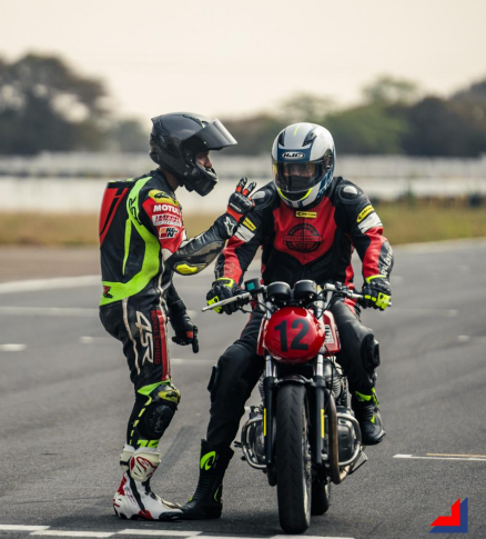 Professional motorcycle coaching session with a trainer guiding a rider on a red racing bike during a track practice.